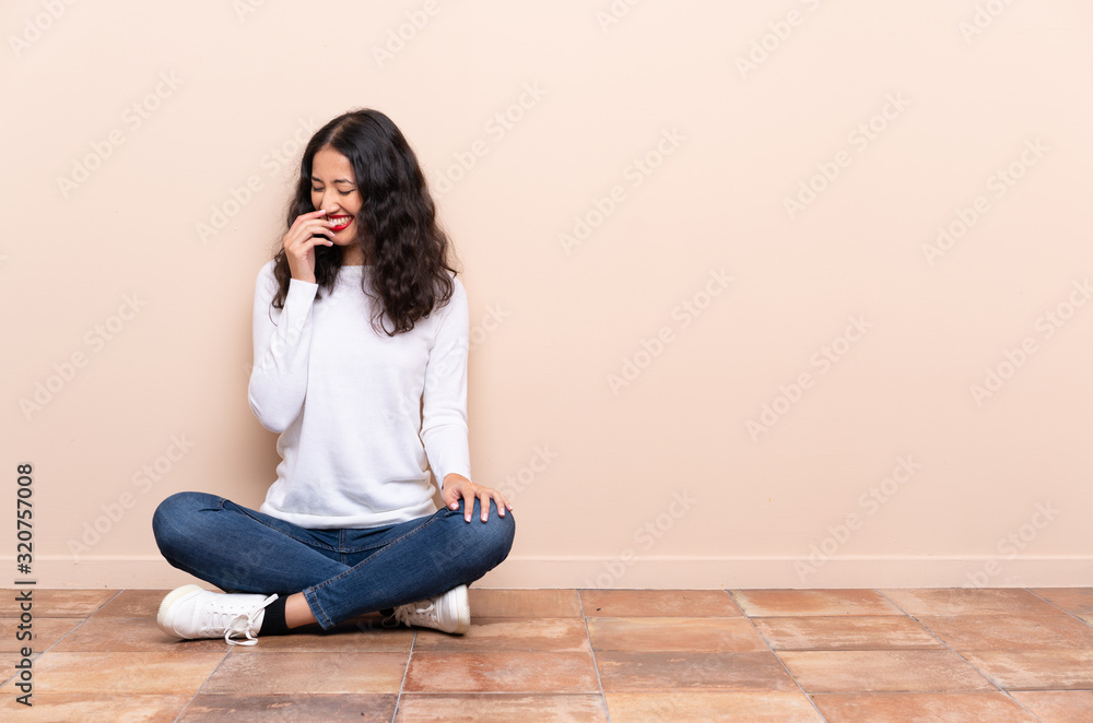 Young woman sitting on the floor smiling a lot