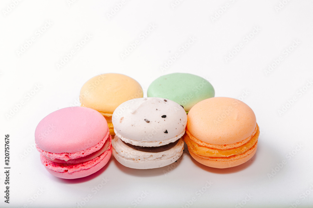 Fototapeta premium French colorful macarons background,Colorful macarons on white background. Macaron or Macaroon is sweet meringue-based confection. Flat lay