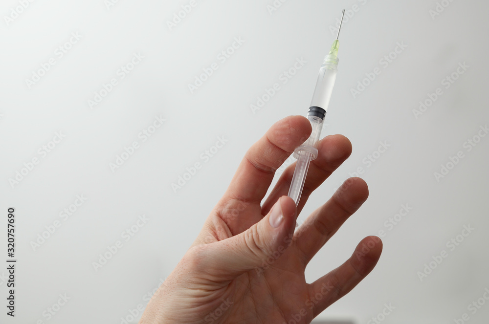 Hand with a syringe on white background Hand with a syringe on white background