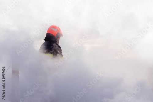 firefighter in smoke muffling a fire in close up