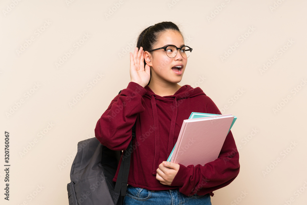 Fototapeta premium Young student Asian girl woman over isolated background listening something