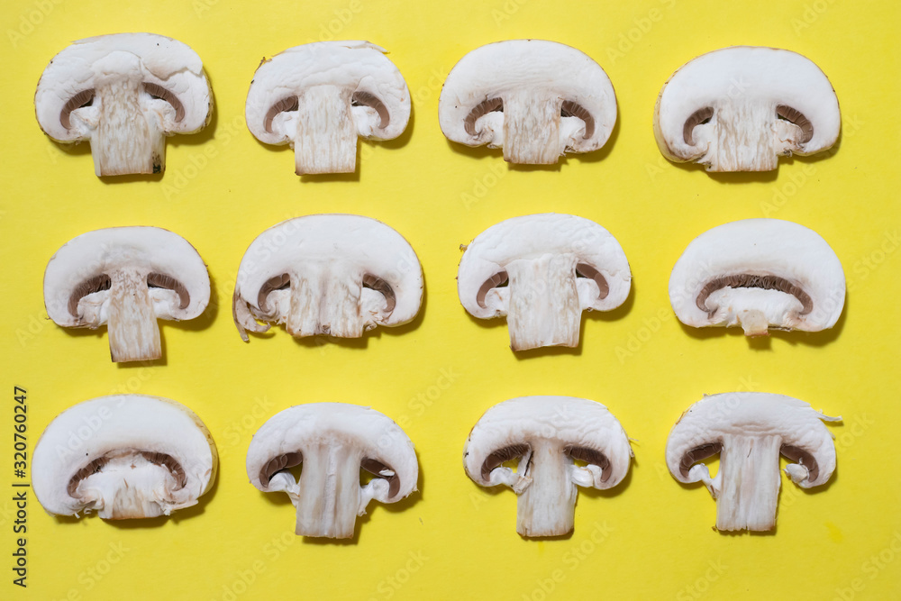 Champignon mushrooms slices on yellow pattern. Vegetarian food Champignon mushrooms slices on yellow pattern. Vegetarian food