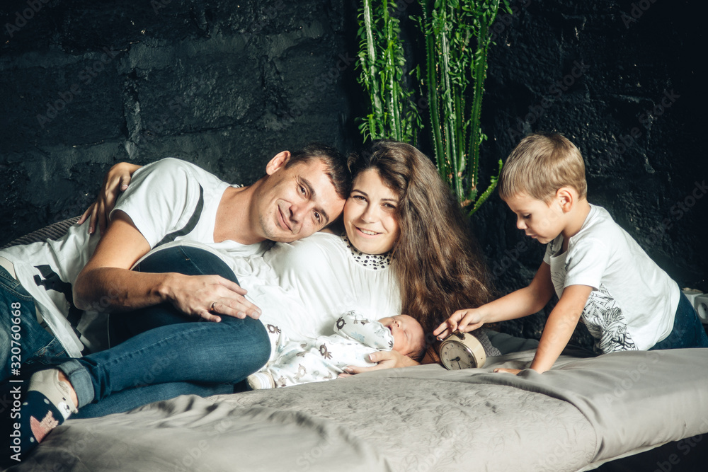 beautiful and happy parents with two children in bed