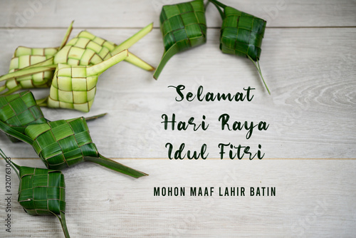 Eid Mubarak celebration card translate in Bahasa Indonesia or Malay language - Selamat Hari Raya Idul Fitri. Mohon maaf lahir batin.. With frame background of Ketupat indonesian traditional food. photo