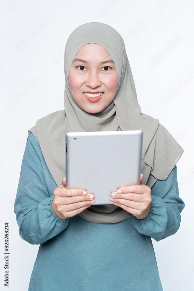Female muslim woman using a tablet device. Female muslim woman using a tablet device.