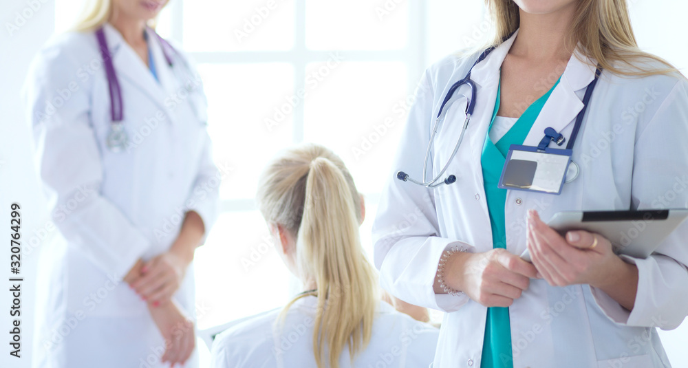 Portrait of three confident female doctors standing with arms crossed at the medical office. Portrait of three confident female doctors standing with arms crossed at the medical office.