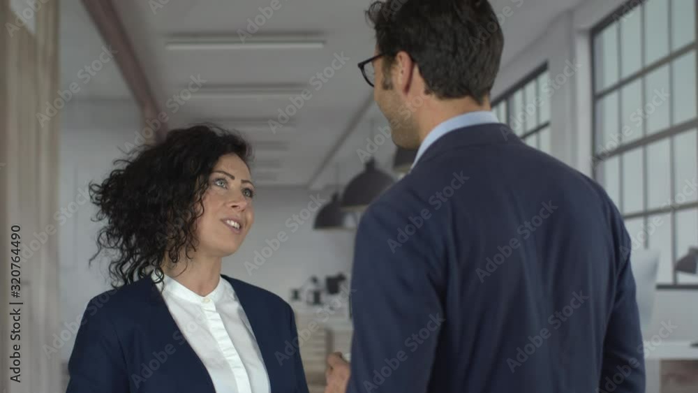 Businessteam talking together and giving hi five for a success a deal an agreement at work. Young attractive businesswoman and businessman working together, collaborate, corporate. Shot in 6k. Businessteam talking together and giving hi five for a success a deal an agreement at work. Young attractive businesswoman and businessman working together, collaborate, corporate. Shot in 6k.