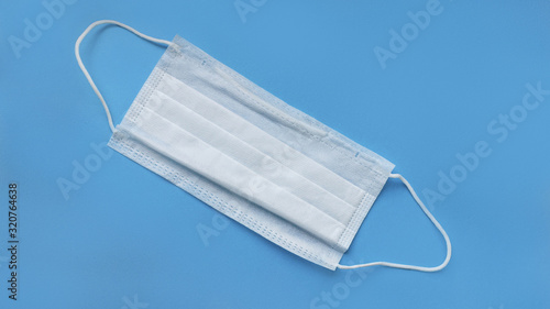 medical mask on cyan, blue background.face mask. mask for diseases. Thermometer and medication.  disposable face image. Medical respiratory bandage face. Concept of coronavirus quarantine.