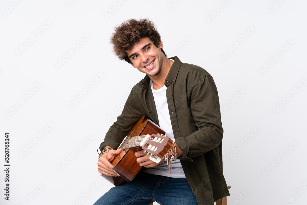 Young caucasian man with guitar over isolated white background looking to the side Young caucasian man with guitar over isolated white background looking to the side