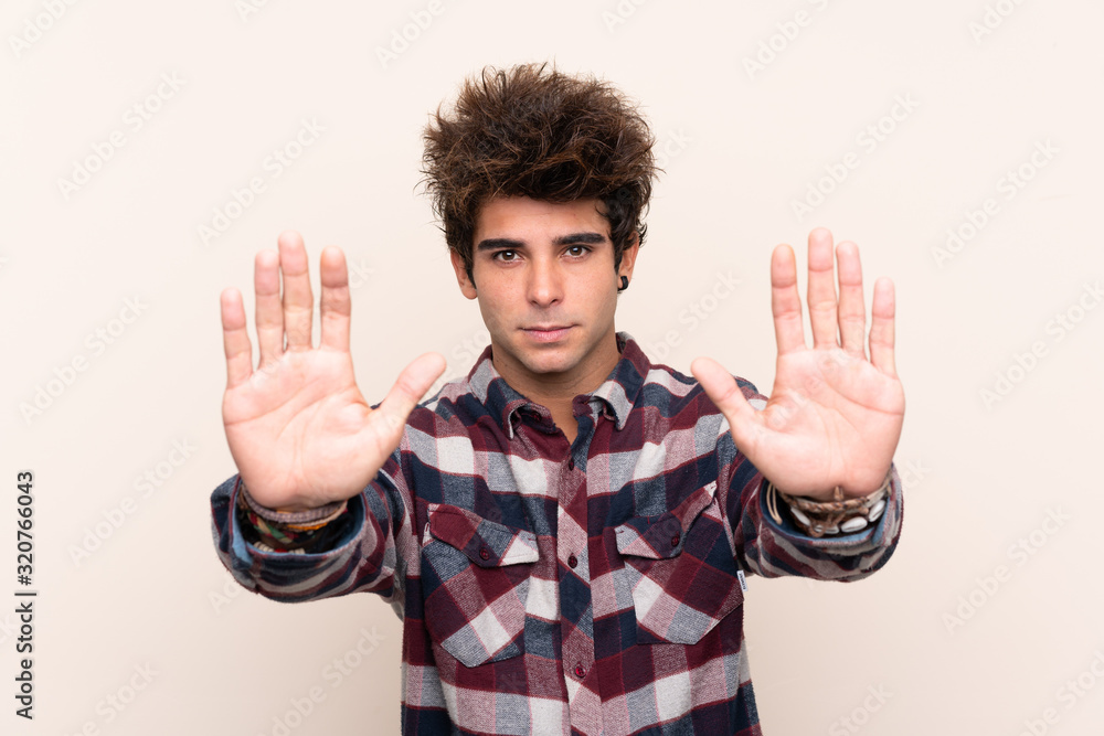 Young caucasian man making stop gesture and disappointed