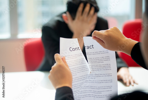 Businessman tearing contract agreement in office - breaking deal contract