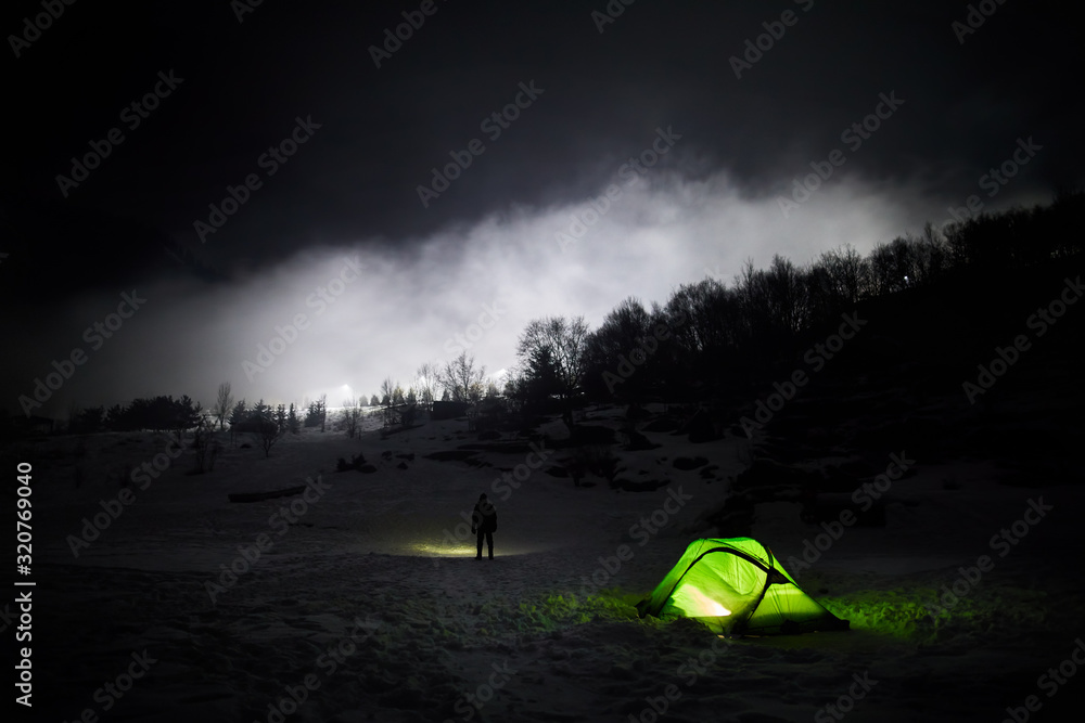 Man near tent at foggy night