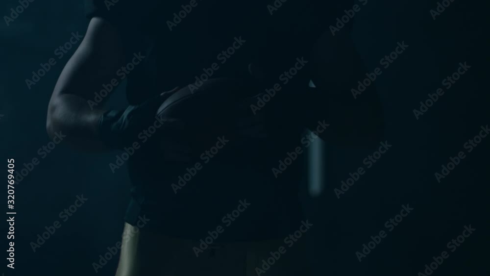CU Portrait of American football player in protective uniform posing against bright flashing lights. Shot on ARRI Alexa Mini 60 FPS slow motion CU Portrait of American football player in protective uniform posing against bright flashing lights. Shot on ARRI Alexa Mini 60 FPS slow motion