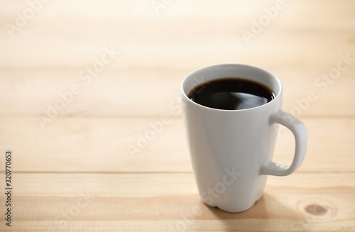 Coffee cup on a blurred wooden board background And free space for entering text