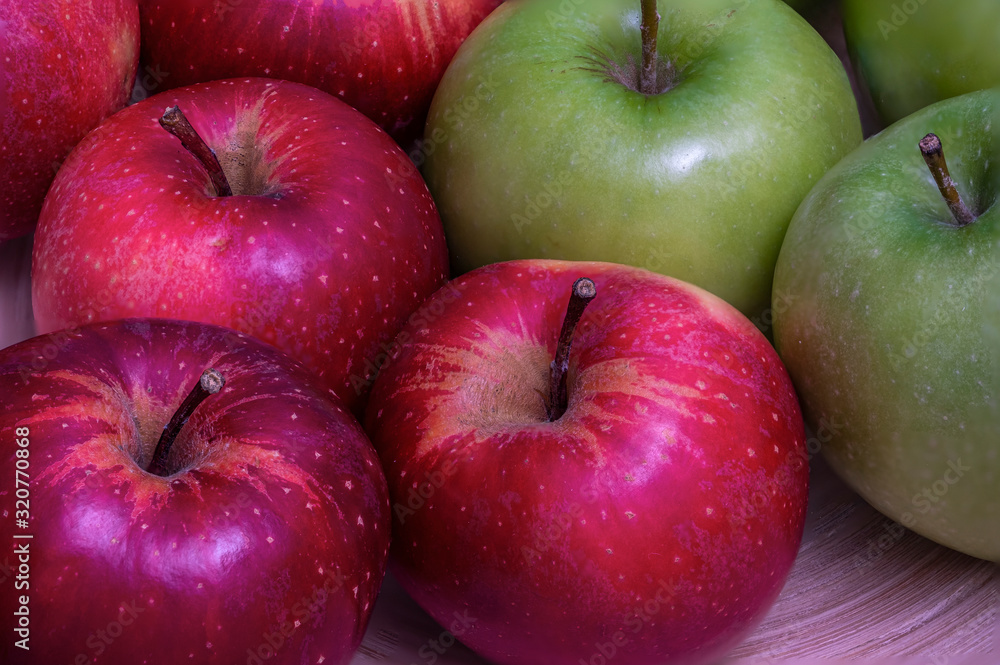 Red and green apples on a bamboo plate Red and green apples on a bamboo plate