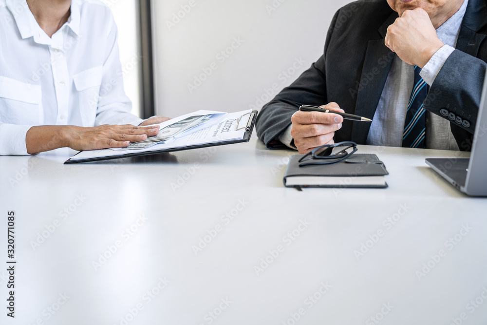 Fototapeta premium Bribery and corruption concept, bribe in the form of dollar bills, Businesswoman giving money while making deal to agreement a real estate contract and financial