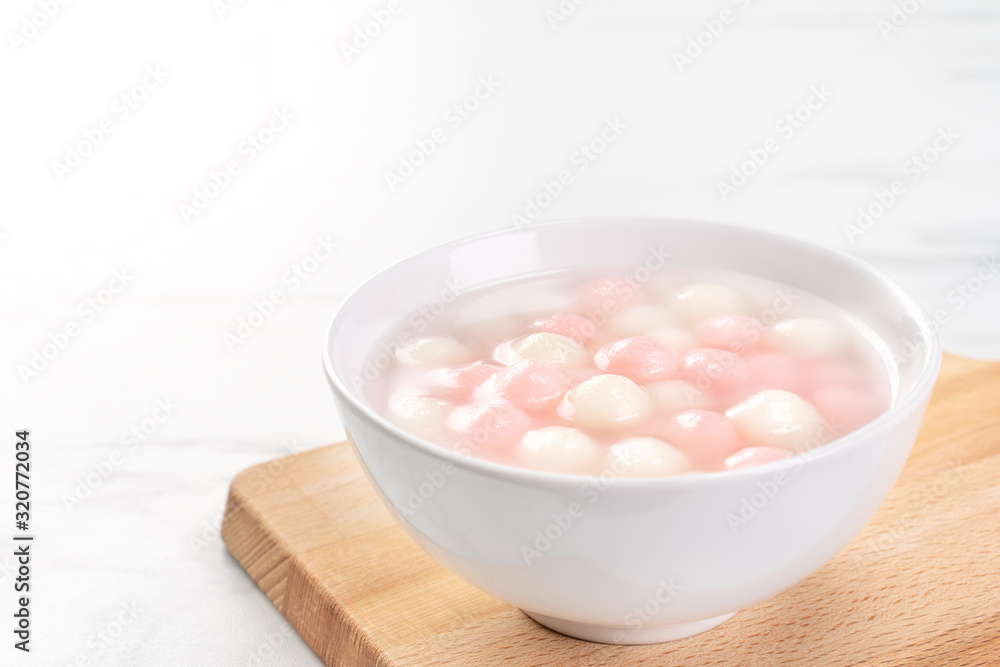 Delicious tang yuan, red and white rice dumpling balls in a small bowl. Asian traditional festive food for Chinese Winter Solstice Festival, close up. Delicious tang yuan, red and white rice dumpling balls in a small bowl. Asian traditional festive food for Chinese Winter Solstice Festival, close up.