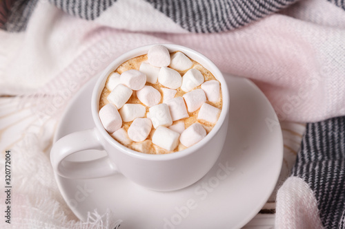 Festive cozy atmosphere. Cup of hot cocoa with marshmallows on background of wool plaid. Mock up. Flatlay