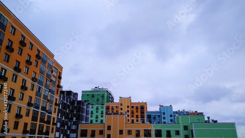 Bright multi-colored multi-storey residential building against a cloudy white sky