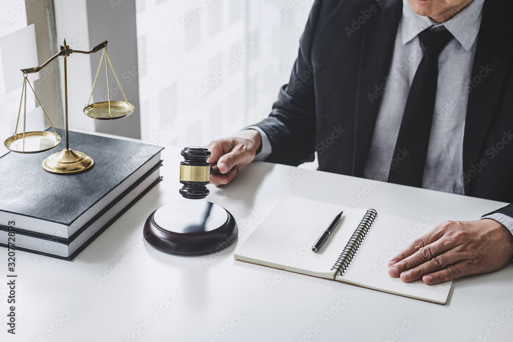 Judge gavel with Justice lawyers, Counselor in suit or lawyer working with contract papers on a documents in courtroom, Legal law, advice and justice concept Judge gavel with Justice lawyers, Counselor in suit or lawyer working with contract papers on a documents in courtroom, Legal law, advice and justice concept