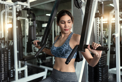 Young asian woman lifting barbell in gym. healthy lifestyle and workout motivation concept.