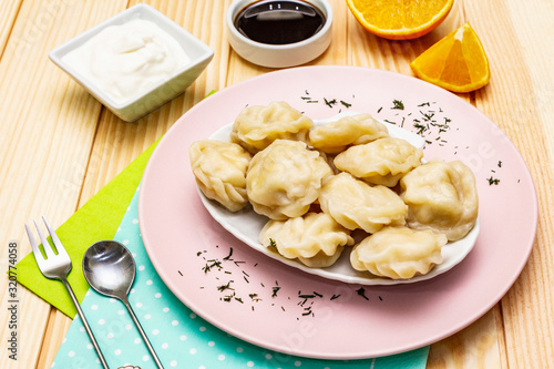 Fish dumplings. The concept of healthy food for children. Sour cream, soy sauce, cutlery. Wood background