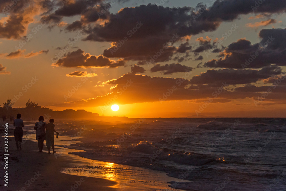 Silhouettes of people at sunset on the Atlantic ocean