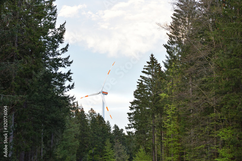 Wind farm windmill with large blades against the background of the evening sky in a European forest Schwarzwald