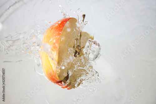 Przekrojone jabłko wpadające do wody
