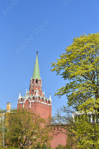 Beautiful Kremlin tower on a background of blue sky and a fresh green tree in spring time