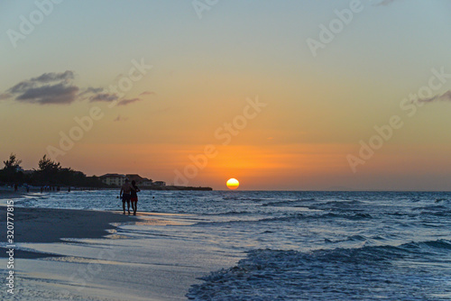 Silhouettes of people at sunset on the beach of Atlantic ocean, Cuba