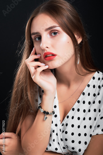 Portrait of a young model in studio against black background.