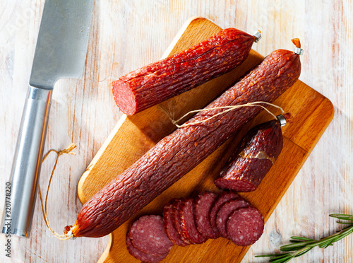 Close-up of smoked  russian sausage at wooden surface photo