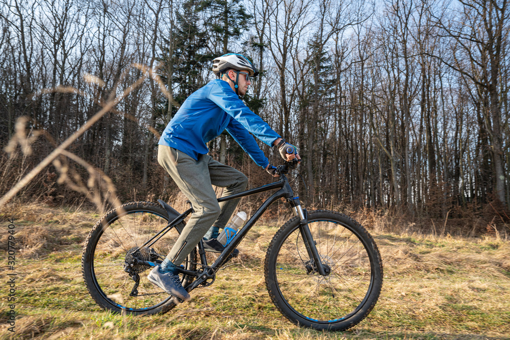 Guy mountain bike rides a bicycle along a forest trail. Sport fitness motivation and inspiration outdoors