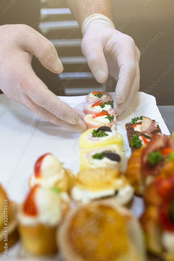 Chef preparing finger food on paper plate for delivery.