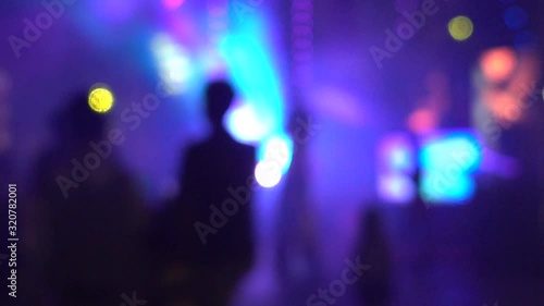 Defocused people are dancing at a party.