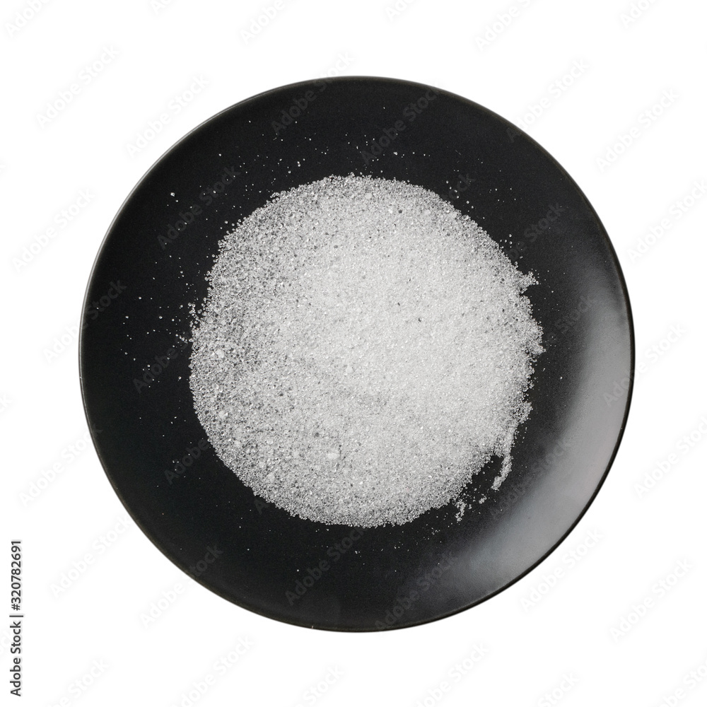 Pile of white citric acid crystals on dark plate isolated