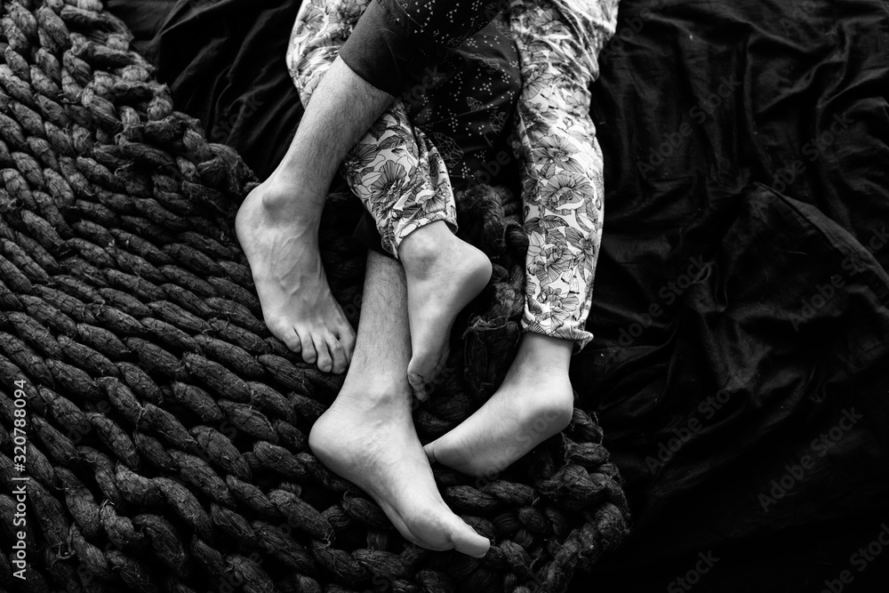 Passionate love Feet of a young couple that lying on the bed at  