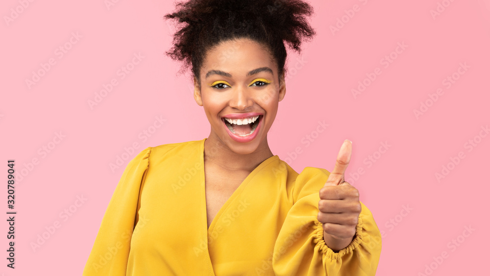 Closeup of afro woman showing thumb up and smiling Closeup of afro woman showing thumb up and smiling