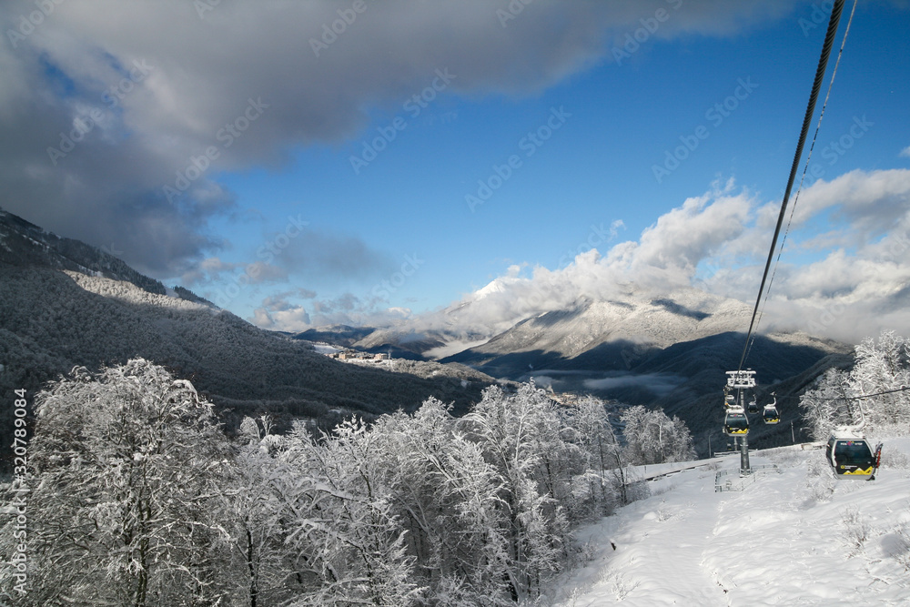 Snow-capped Caucasus mountains and Rosa Khutor ski resort cable car, Sochi, Russia.
