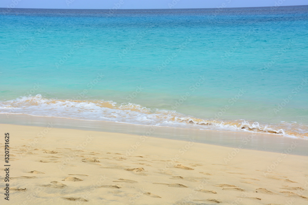 Natural background, a beautiful sandy beach and turquoise, blue calm  ocean, sea  on a sunny day on Sal Island in Cape Verde, Cab