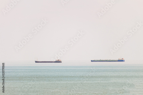 Two freight ship in sea on heat hazy horizon photo