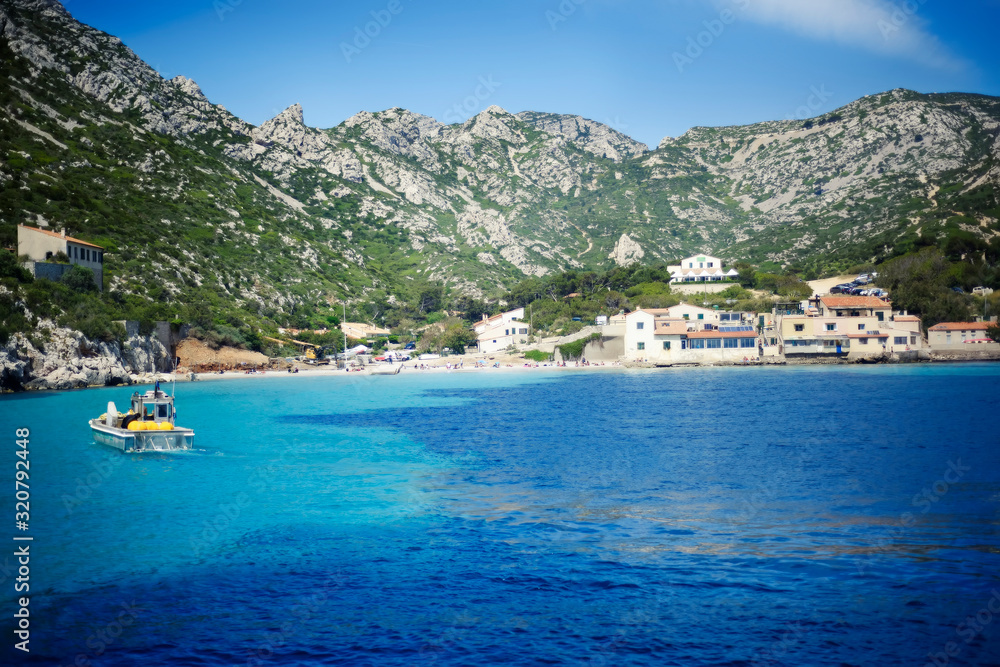 Coastal landscape with blue sea water and white and green mountains around between Cassis and Marseille in Provence, France, named Calanques in french. Scenic sea summer landscape with boat. Travel