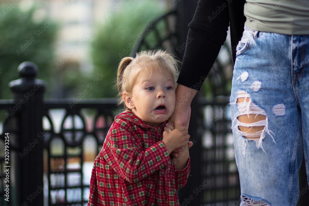 © Tatiana Foxy - Funny and scared face of the caucasian child of two years old holding mother hand