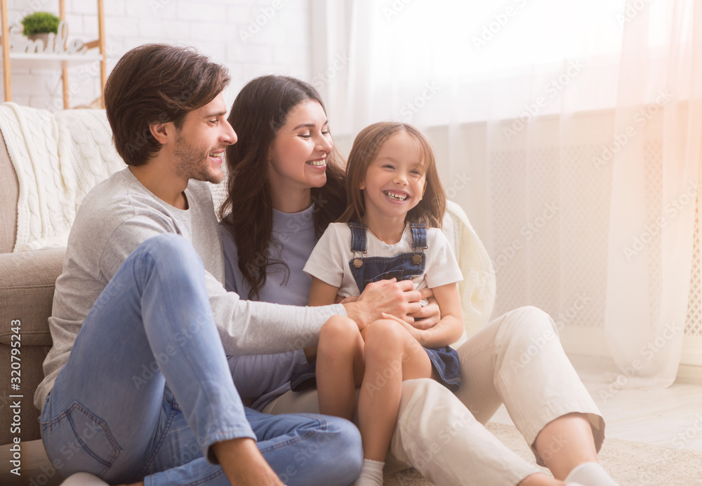 Loving parents tickling their little daughter, having fun together at home. Loving parents tickling their little daughter, having fun together at home.