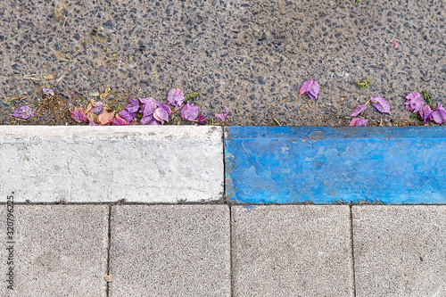 White and blue colored curbstone on the Israeli street which indicates a paid parking photo