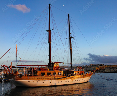 A two masted sailing ship lies at anchor in the harbour at Sliema in Malta.