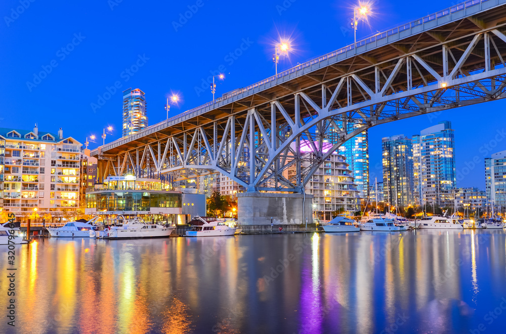 Granville Bridge and Vancouver BC skyline reflection at blue hour in Canada