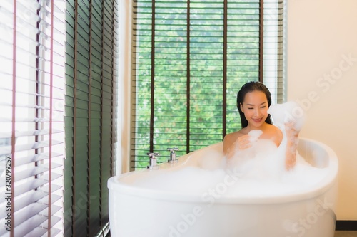 Portrait beautiful young asian woman happy smile relax take a bath in bathtub