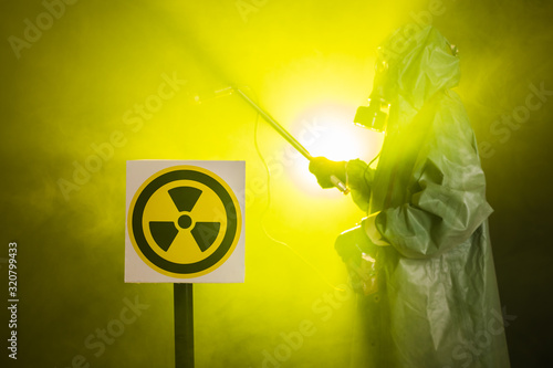 Radiation and danger concept - Man in old protective hazmat suit photo